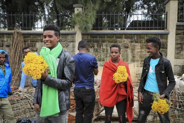 Young men sell bunches of flowers at Sholla Market, the day before the Ethiopian New Year, in Addis Ababa, Ethiopia Saturday, September 10, 2022. (Photo by AP Photo/Stringer)