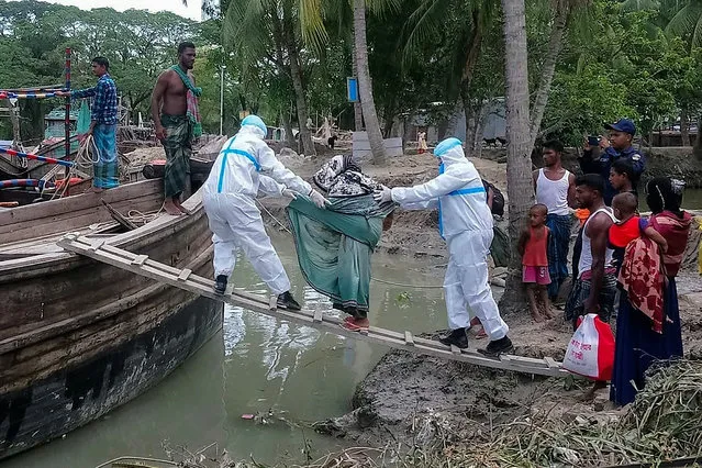 This handout photo taken on May 19, 2020 and released by the District Administration of Bhola shows residents being evacuted in Dhalchar village on the island of Bhola as Cyclone Amphan barrels towards Bangladesh's coast. Millions of people were being moved to safety as one of the fiercest cyclones in years barrelled towards India and Bangladesh on May 19, but with evacuation plans complicated by coronavirus precautions. “Amphan” is expected to pack winds gusting up to 185 kilometres (115 miles) per hour when it hits eastern India and Bangladesh on May 20 afternoon or evening, and with a storm surge of several metres, forecasters said. (Photo by District Administration of Bhola/AFP Photo)