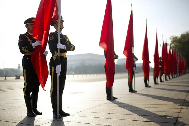 An officer unfurls the flag of a Chinese honor guard member before a welcome ceremony for Russian Prime Minister Dmitry Medvedev at the Great Hall of the People in Beijing, Wednesday, November 1, 2017. (Photo by Mark Schiefelbein/AP Photo)