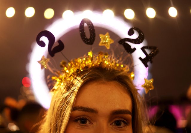 A reveller wears a 2024 headband during the New Year Eve firework celebrations on the River Thames in London, Britain on December 31, 2023. (Photo by Neil Hall/EPA/EFE/Rex Features/Shutterstock)