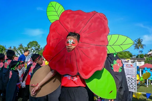 A boy wears a costume of Malaysia's national flower hibiscus before marching during a school sports day in Karak, Malaysia's Pahang state, on August 27, 2022. (Photo by Mohd Rasfan/AFP Photo)
