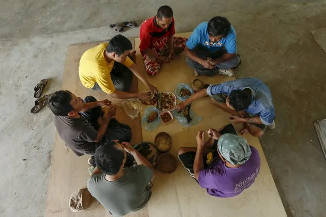 A group of workers have lunch on the floor in Udon Thani, Thailand, September 15, 2015. (Photo by Jorge Silva/Reuters)
