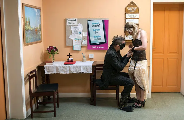 Steampunk enthusiasts fix their attire in a church hall on the first day of “The Asylum Steampunk Festival” in Lincoln, northern England on August 26, 2016.
The four-day alternative lifestyle festival is the largest and longest running steampunk festival in the World; combining art, literature, music, fashion and comedy. Steampunk is a subgenre of science fiction or science fantasy that incorporates technology and aesthetic designs inspired by 19th-century industrial steam-powered machinery. (Photo by Oli Scarff/AFP Photo)