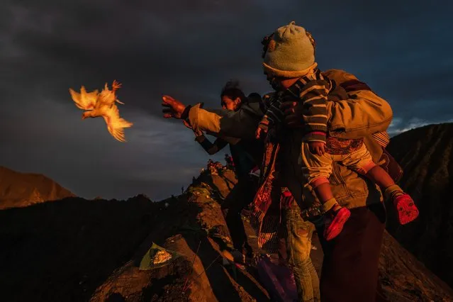 A Tenggerese worshipper, Harjono, throw a chicken as offerings during the Yadnya Kasada Festival at crater of Mount Bromo amid the coronavirus pandemic on July 07, 2020 in Probolinggo, East Java, Indonesia. Tenggerese people are a Javanese ethnic group in Eastern Java who claimed to be the descendants of the Majapahit princes. Their population of roughly 500,000 is centered in the Bromo Tengger Semeru National Park in eastern Java. The most popular ceremony is the Kasada festival, which makes it the most visited tourist attraction in Indonesia. The festival is the main festival of the Tenggerese people and lasts about a month. On the fourteenth day, the Tenggerese made a journey to Mount Bromo to make offerings of rice, fruits, vegetables, flowers and livestock to throw them into the volcano's caldera. The origin of the festival lies in the 15th century princess named Roro, the principality of Tengger with her husband Joko Seger, and the childless couple asked mountain Gods for help in bearing children. The legend says the Gods granted them 24 children but on the provision that the 25th must be added to the volcano in sacrifice. The 25th child, Kesuma, was finally sacrificed in this way after an initial refusal, and the tradition of throwing sacrifices into the Caldera to appease the mountain Gods continues today. (Photo by Ulet Ifansasti/Getty Images)
