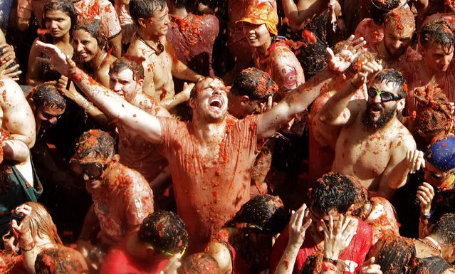 Revelers enjoy as they throw tomatoes at each other, during the annual “Tomatina”, tomato fight fiesta, in the village of Bunol, 50 kilometers outside Valencia, Spain, Wednesday, August 31, 2016. (Photo by Alberto Saiz/AP Photo)