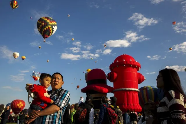 Attendees watch as hundreds of hot air balloons lift off on the first day of the 2015 Albuquerque International Balloon Fiesta in Albuquerque, New Mexico, October 3, 2015. (Photo by Lucas Jackson/Reuters)