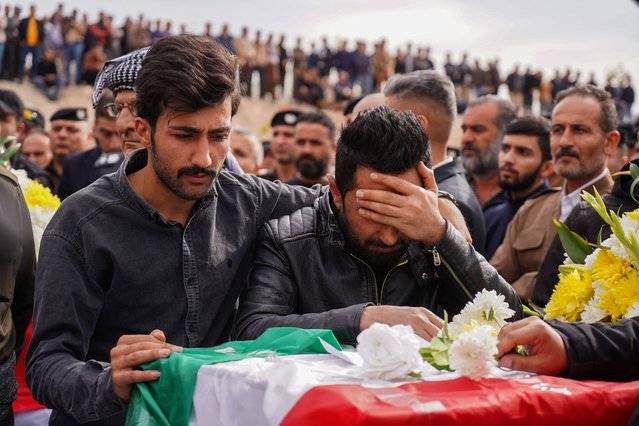 Mourners react during the funeral of people killed in a gas leak explosion at a student dormitory building, in Dohuk in Iraq's autonomous Kurdistan region, on November 22, 2022. Five people died and 40 were injured in northern Iraq in a fire caused by a gas leak explosion at a student dormitory, authorities announced. The explosion occurred on November 21, 2022, at night when a rooftop gas tank leaked at a building housing a bakery and student accommodation in the Kurdish city of Dohuk. (Photo by Ismael Adnan/AFP Photo)