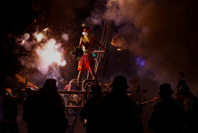A volunteer is pelted with exploding firecrackers as part of the Lantern Festival celebrations during the tradition, Blasting Lord Handan in Taitung, Taiwan on February 24, 2024. (Photo by Ann Wang/Reuters)