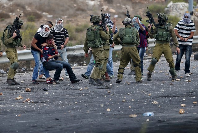 Undercover Israeli security personnel and Israeli soldiers detain a wounded Palestinian protester during clashes near the Jewish settlement of Bet El, near the West Bank city of Ramallah October 7, 2015. (Photo by Mohamad Torokman/Reuters)
