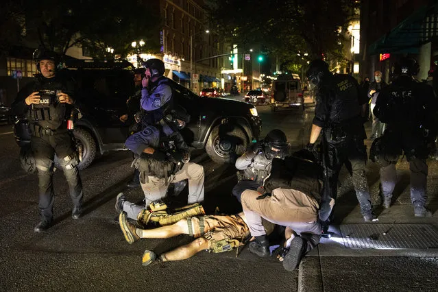 A man is being treated after being shot Saturday, August 29, 2020, in Portland, Ore. Fights broke out in downtown Portland Saturday night as a large caravan of supporters of President Donald Trump drove through the city, clashing with counter-protesters. (Photo by Paula Bronstein/AP Photo)
