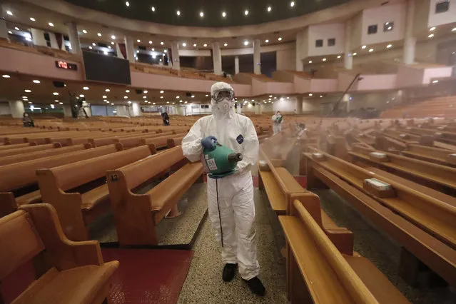 A public official disinfects as a precaution against the coronavirus at the Yoido Full Gospel Church in Seoul, South Korea, Friday, August 21, 2020. South Korea's Centers for Disease Control and Prevention on Friday reported new infections from practically all major cities nationwide, including Busan, Gwangju, Daejeon, Sejong and Daegu, a southeastern city that was the epicenter of a massive outbreak in late February and March. (Photo by Ahn Young-joon/AP Photo)