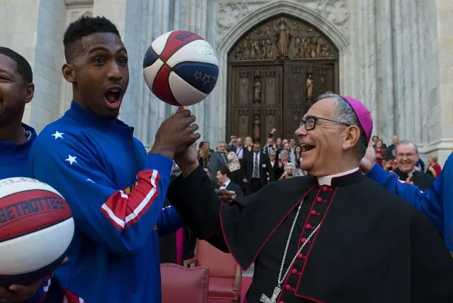 Bishop Dominick Lagonegro spins a basketball on his finger with the help of the Harlem Globetrotters in front of St. Patrick's Cathedral during the Columbus Day Parade on Fifth Ave. in the Manhattan borough of New York, October 12, 2015. (Photo by Stephanie Keith/Reuters)