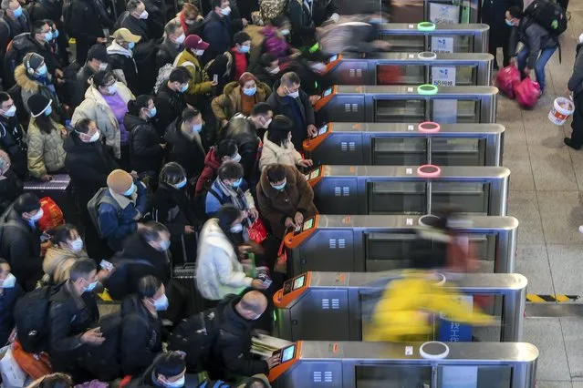 In this photo released by Xinhua News Agency, People wearing face masks with their luggage rush to catch their trains at the railway station in Suzhou in east China's Jiangsu Province, Saturday, January 7, 2023. China is now facing a surge in COVID-19 outbreak cases and hospitalizations in major cities and is bracing for a further spread into less developed areas with the start of the Lunar New Year travel rush, set to get underway in coming days. (Photo by Li Bo/Xinhua via AP Photo)