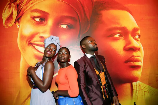 Actors Lupita Nyong'o (L), Madina Nalwanga (C) and David Oyelowo pose in the same manner as they appear on the movie poster seen behind him during the Los Angeles premiere of “Queen of Katwe” in Hollywood, California September 20, 2016. (Photo by Danny Moloshok/Reuters)