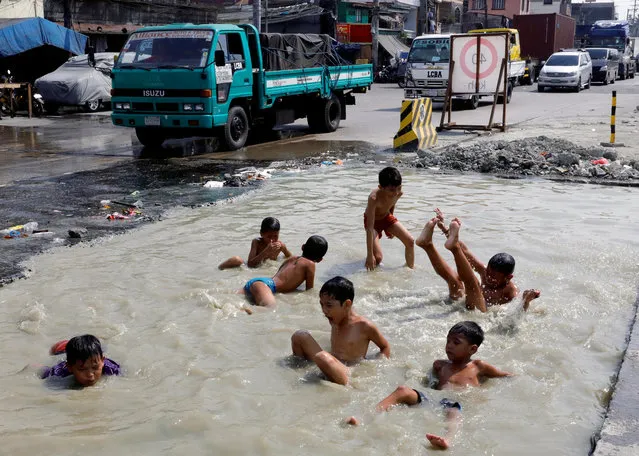 Young boys swim in a road under repair in Tondo district, metro Manila, Philippines February 1, 2018. (Photo by Dondi Tawatao/Reuters)