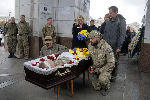 Soldiers  pay their respect to well-known Ukrainian volunteer Yuriy Mosin, in Kiev central Independence square, Ukraine, Wednesday, September 28, 2016. Mosin, born in Donetsk, was a co-founder of the International Alliance for Fraternal Assistance engaged in volunteer assistance to servicemen fighting in a war conflict zone in the country's east since 2013. He died unexpectedly on Sunday. (Photo by Efrem Lukatsky/AP Photo)