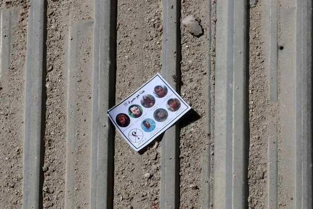 One of the warning leaflets dropped by the Syrian army is seen in the rebel held Tariq al-Bab neighbourhood of Aleppo, Syria September 25, 2016. The leaflet reads (top) “This is your destiny!!!” and (bottom L) “who is next” as it depicts pictures of killed rebel commanders and fighters. (Photo by Abdalrhman Ismail/Reuters)