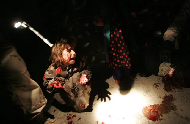 Samar Hassan screams after her parents were killed by U.S. Soldiers with the 25th Infantry Division in a shooting January 18, 2005 in Tal Afar, Iraq. The troops fired on the Hassan family car when it unwittingly approached them during a dusk patrol in the tense northern Iraqi town. Parents Hussein and Camila Hassan were killed instantly, and a son Rakan, 11, was seriously wounded in the abdomen. (Photo by Chris Hondros/The Atlantic)