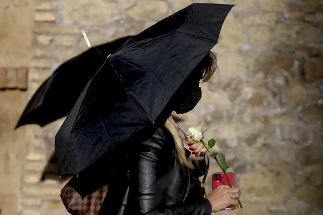 A woman holds an umbrella and a rose during a protest against tightening of Poland’s already restrictive abortion law, in front of the Polish Embassy in Rome, Wednesday, October 28, 2020. Poland’s constitutional court declared that aborting fetuses with congenital defects is unconstitutional. Poland already had one of Europe’s most restrictive abortion laws, and the ruling will result in a near-complete ban on abortion. (Photo by Cecilia Fabiano/LaPresse via AP Photo)