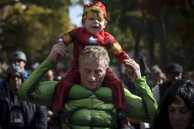 A child dressed as Ironman rides on an adult's shoulders who is dressed up as the Hulk as they take part in the Children's Halloween day parade at Washington Square Park in the Manhattan borough of New York October 31, 2015. (Photo by Carlo Allegri/Reuters)