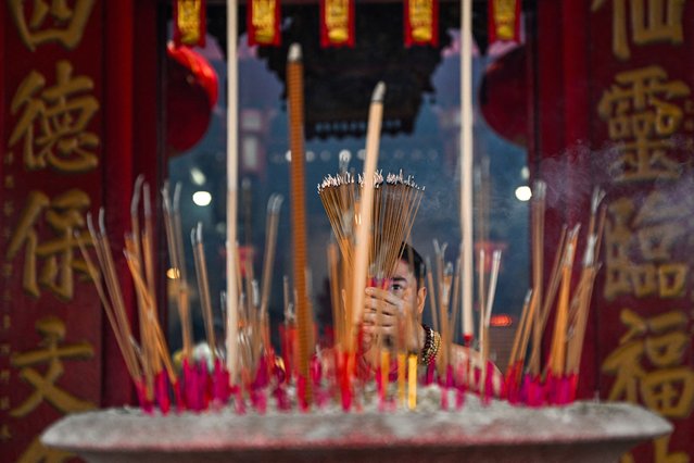 An ethnic Malaysian Chinese man burns incense as he offers prayers on the first day of the Lunar New Year of the Snake at Kwong Fook Temple in Bentong, Malaysia's Pahang state on January 29, 2025. Hundreds of millions of people across Asia celebrate the Lunar New Year with their families on January 29, as they bid farewell to the Year of the Dragon and usher in the Year of the Snake. (Photo by Mohd Rasfan/AFP Photo)