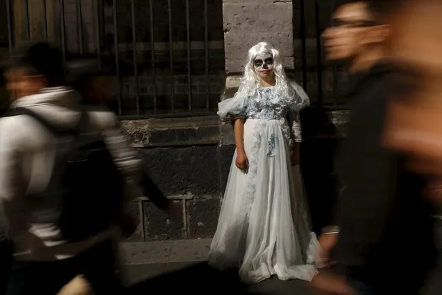 A girl dressed up as a dead woman is seen during the Catrinas parade in Mexico City October 31, 2015. The Catrina is a Mexican character also known as "The Elegant Death". (Photo by Carlos Jasso/Reuters)