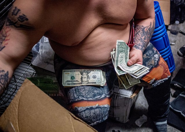 Lil Show Redneck Brawler counts out his money after the show at Johnson' s Station in Picayune, Ms., on February 11, 2018. (Photo by Emily Kask/AFP Photo)