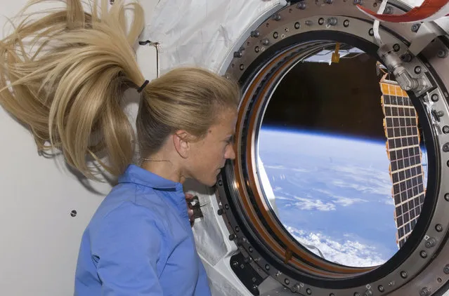 Astronaut Karen Nyberg looks through a window in the newly installed Kibo laboratory of the International Space Station on June 11, 2008. (Photo by Reuters/NASA)