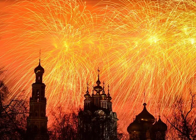 Fireworks burst behind cathedrals of the Novodevichy Convent during an event marking Defender of the Fatherland Day in Moscow on February 23, 2023. (Photo by Yuri Kadobnov/AFP Photo)
