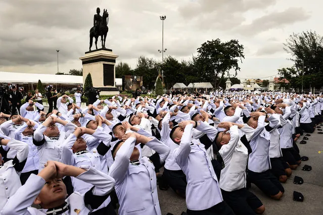 Thai boys in uniform prostrate in front of the statue of King Rama V, before a Buddhist ceremony in honour of the late Thai king Bhumibol Adulyadej in Bangkok on June 9, 2017. (Photo by Lillian Suwanrumpha/AFP Photo)