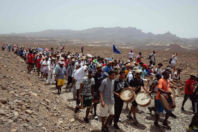 Pilgrims take part in the São João Baptista pilgrimage in Porto Novo on June 23, 2024. São João Baptista is one of the most popular celebrations of the pilgrimage on Santo Antão’s Island. During the procession, pilgrims walk to the beating of the drums for 23 kilometers in a demonstration of their faith and devotion to the Saint. It is an occasion to make promises and thank the saint for their achievements. (Photo by Queila Fernandes/AFP Photo)