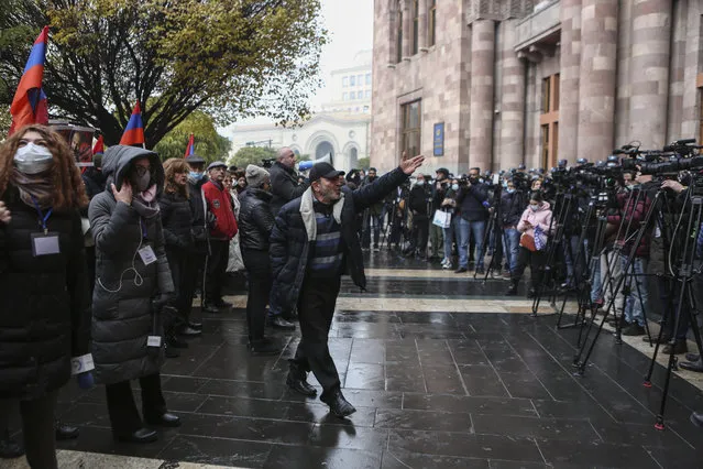 A protester gestures as media cover a rally demanding the resignation of the country's prime minister over his handling of the conflict with Azerbaijan over Nagorno-Karabakh in Republic Square in Yerevan, Armenia, Thursday, December 10, 2020. (Photo by Hrant Khachatryan/PAN Photo via AP Photo)