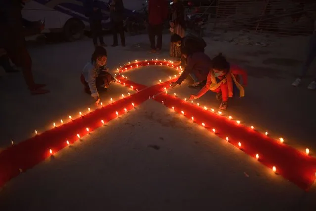 Nepalese people lit candles around the symbol of RED AIDS during Eve of the 33rd World AIDS Day celebrated in Kathmandu, Nepal on Monday, November 30, 2020. World AIDS Day is celebrated worldwide on December 1st of every year to raise the awareness in the fight against HIV. (Photo by Narayan Maharjan/NurPhoto via Getty Images)