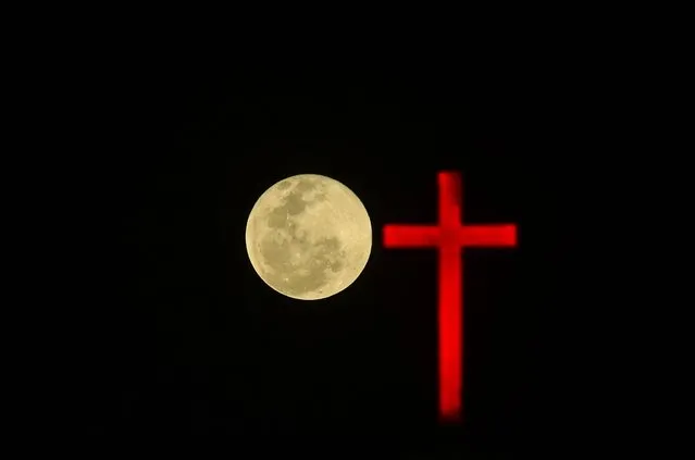 The Full Pink Moon rises behind a cross on the dome of the Annai Velankanni Shrine in Chennai, India, 06 April 2023. The first Full Moon of spring, which rises in April, is known as the Pink Moon. (Photo by Idrees Mohammed/EPA/EFE/Rex Features/Shutterstock)