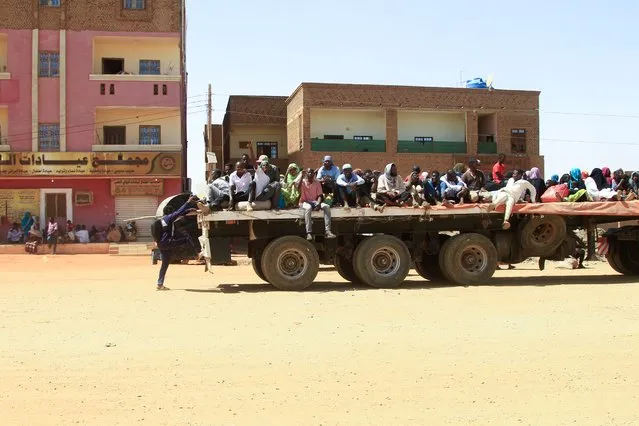 People fleeing street battle between the forces of two rival Sudanese generals, are transported on the back of a truck in the southern part of Khartoum, on April 21, 2023. Hundreds of people have been killed and thousands wounded since the fighting erupted on April 15 between forces loyal to Sudan's army chief and the commander of the powerful paramilitary Rapid Support Forces (RSF). (Photo by Ebrahim Hamid/AFP Photo)