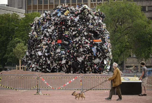 A giant globe of 35 tons of garbage is photographed on June 19, 2013 in the center of Geneva. The city of Geneva has launched a campaign against the tons of litter by exhibiting on Plainpalais place, a giant ball that gather the rubbish collected off bins in three days. (Photo by Fabrice Coffrini/AFP Photo)