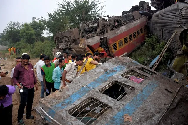 Rescue workers search for survivors after two passenger trains collided in Balasore district in the eastern state of Odisha, India on June 3, 2023. (Photo by Reuters/Stringer)