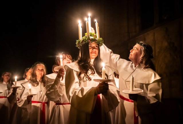 Alida Freding wears a crown of candles symbolising St Lucy as she leads the celebration of Sankta Lucia: Festival of Light at York Minster, based on the bravery and martyrdom of a young Sicilian girl St Lucy who died in the early fourth century. The service is run as a partnership between York Minster and York Anglo-Scandinavian Society (YASS) on Monday, December 16, 2024. In Sweden, Lucia is one of the most significant traditions in the calendar, a symbol and celebration of light and a part of the Advent season. Her name and story reached Sweden along with Christianity and she remained popular even after the Reformation as the bringer of light during the long darkness of winter. (Photo by Danny Lawson/PA Images via Getty Images)
