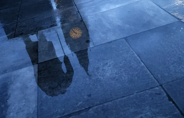 The statue of Britain's former Prime Minister Winston Churchill is reflected onto the rain covered pavement in front of the Houses of Parliament in London, January 30, 2015. Today marks the 50th anniversary of the funeral of Churchill, Britain's wartime leader. (Photo by Eddie Keogh/Reuters)