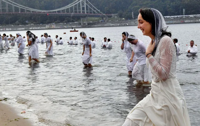 Ukrainian Evangelical Protestants take part in a mass baptism in the river Dniper in Kiev on July 22, 2018. Ukrainian Evangelical Protestant churches held a large-scale baptism in the Dniper river waters of about 500 people to mark the 1030th anniversary of the Christianization of the Kievan Rus. (Photo by Sergei Supinsky/AFP Photo)