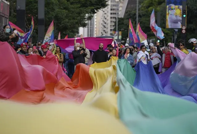 Activists march holding a giant rainbow flag in support of gay rights on the International Day Against Homophobia, Transphobia, Biphobia and against Brazil's President Jair Bolsonaro in Sao Paulo, Brazil, Tuesday, May 17, 2022. (Photo by Andre Penner/AP Photo)
