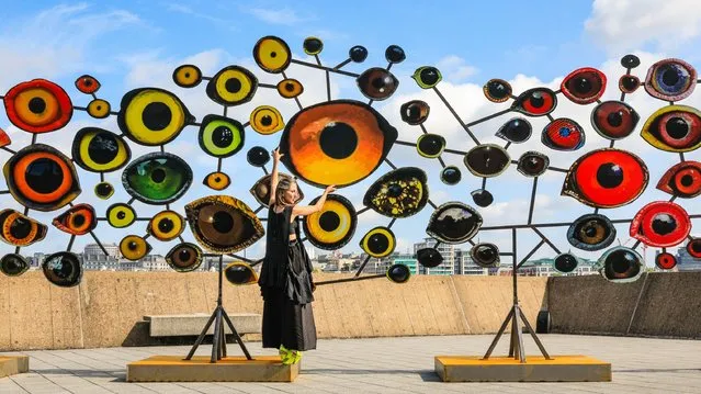 Artist Jenny Kendler puts the finishing touches to her colourful installation “Birds Watching III” (2018) on the rooftop of the Hayward Gallery, together with a scientist from the Zoological Society of London (ZSL) in London, UK on June 19, 2023. “Dear Earth: Art and Hope in a Time of Crisis” features the work of 15 artists, who explore the interdependence of ecologies and ecosystems, as well as our emotional connection with nature. The exhibition runs at the Hayward Gallery from 21 June. (Photo by Edler Images/Alamy Live News)