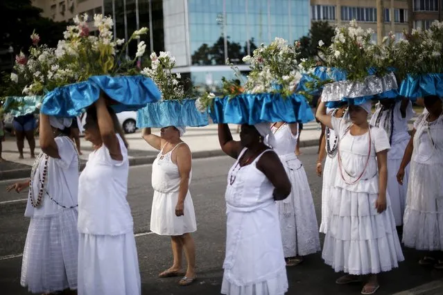 Followers of the Afro-Brazilian religion Umbanda carry offerings for Iemanja, goddess of the sea, at Copacabana Beach in Rio de Janeiro December 27, 2015. Worshippers present gifts to the sea goddess at the end of every year, to give thanks and ask for blessings for the upcoming new year. (Photo by Lunae Parracho/Reuters)