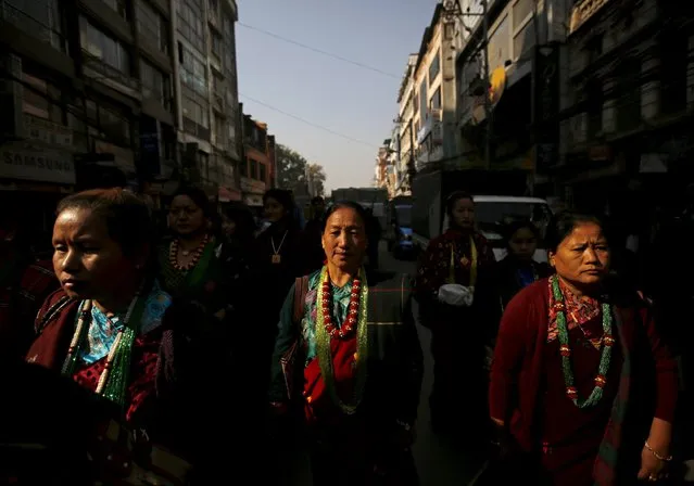 Light illuminates Gurung women as they walk along the road during the New Year parade in Kathmandu, Nepal December 30, 2015. (Photo by Navesh Chitrakar/Reuters)