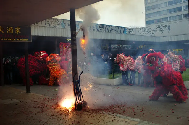 Firecrackers explode as Lion dancers perform in front of a restaurant at the Chinatown district of Paris, to celebrate the Chinese New Year, in Paris, Thursday, February 19, 2015. (Photo by Thibault Camus/AP Photo)