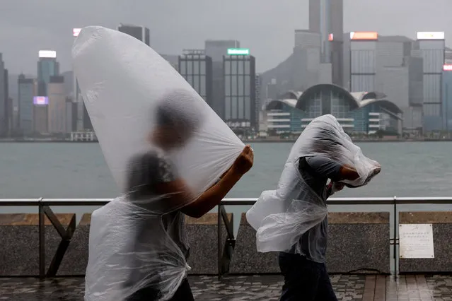 People brave strong winds as Super Typhoon Saola approaches, in Hong Kong, China on September 1, 2023. (Photo by Tyrone Siu/Reuters)