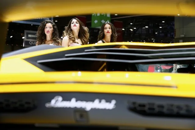 Models pose next to a Lamborghini Aventador SV sports car during the second press day ahead of the 85th International Motor Show in Geneva March 4, 2015.  REUTERS/Arnd Wiegmann   