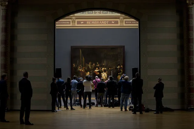 Journalists attend a press conference where the announcement was made that Rembrandt's Night Watch, rear, will be restored next year in the public eye at the Rijksmuseum in Amsterdam, Netherlands, Tuesday, October 16, 2018. (Photo by Peter Dejong/AP Photo)