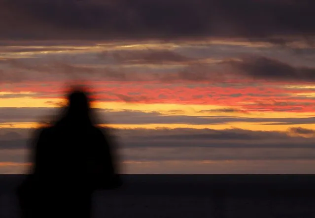 A man looks out at clouds floating across the Pacific Ocean after sunset in Encinitas, California January 19, 2016. (Photo by Mike Blake/Reuters)