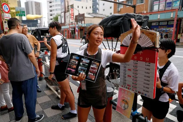 Rickshaw puller Shiori Yoshida, 28, attracts tourists to the guided tour at the Asakusa district in Tokyo, Japan on August 22, 2023. Pullers walk or run an average of 20 km (12 miles) a day and, in addition to being physically strong, they must have extensive knowledge of Tokyo and know how to engage with the tourists who mostly hire them for sightseeing. “I have fun and enjoy myself”, Yoshida said. “In order for the customers to enjoy themselves, I also enjoy myself”. (Photo by Issei Kato/Reuters)